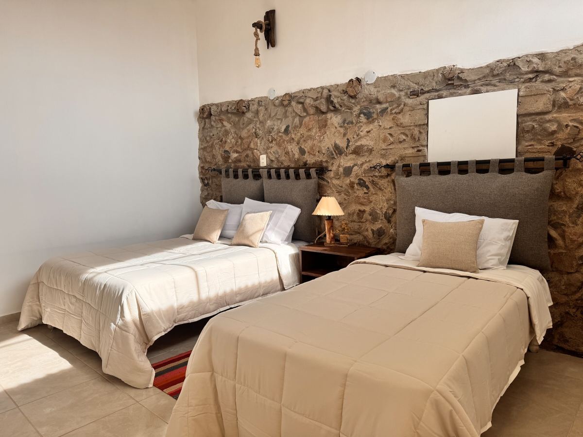 Zimmer mit zwei Betten und Steinwand